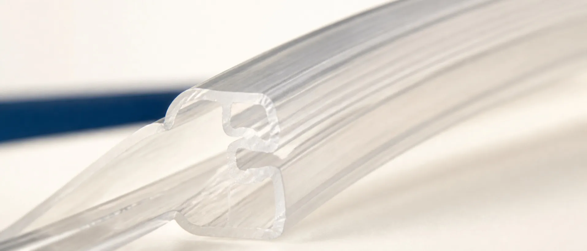 Macro view of a translucent press-to-close zipper profile, showing the interlocking rib geometry